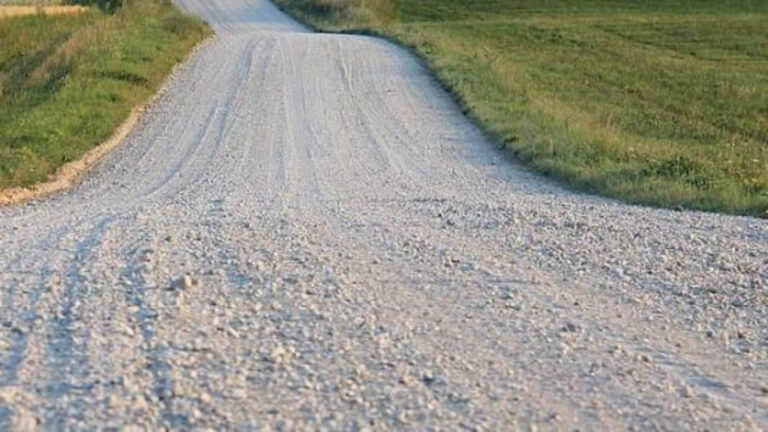 Gravel road splitting into two paths in field